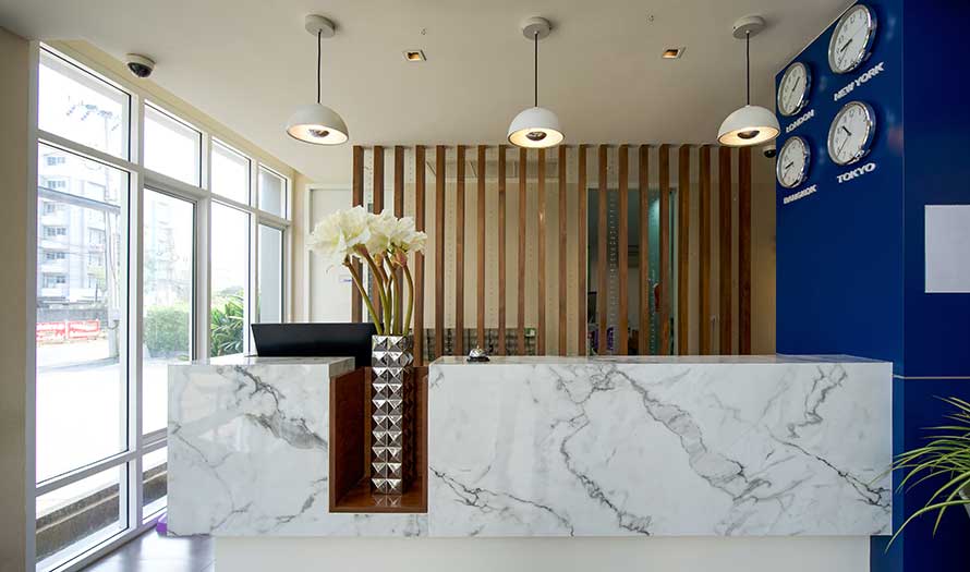 A close-up of a long white marble reception counter in the hotel foyer.