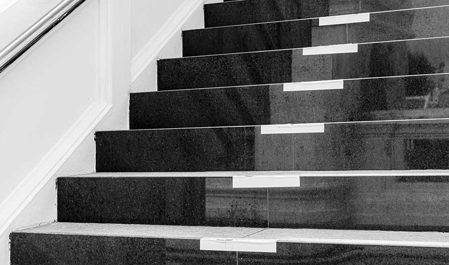 A close-up of a Black marble staircase and outdoor Granite floor.